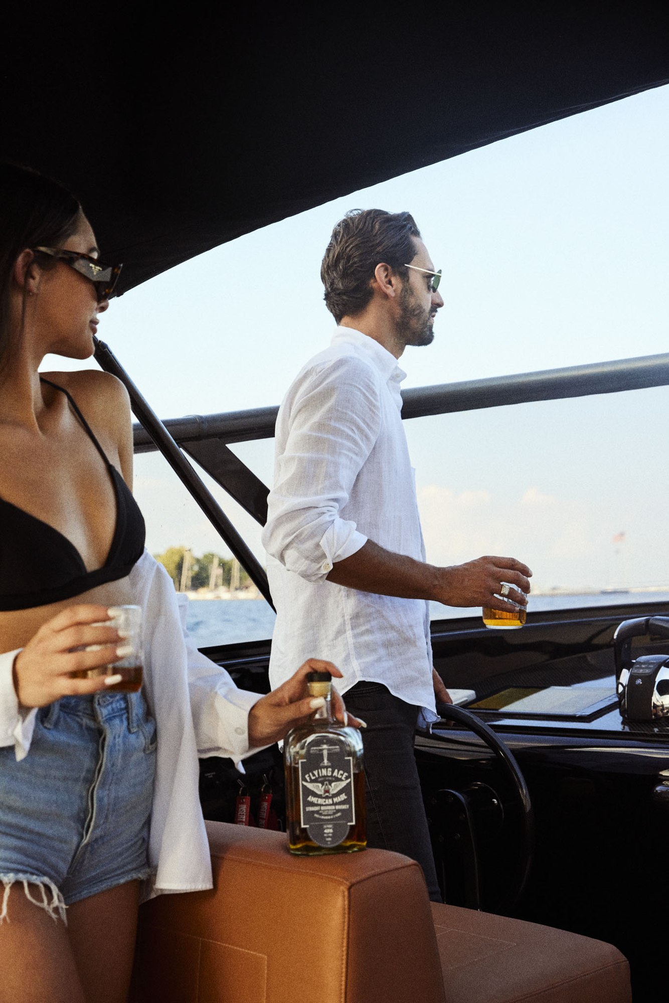 A couple enjoying Flying Ace whiskey aboard a boat